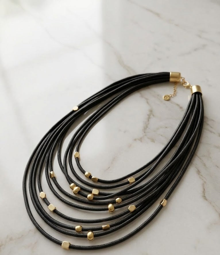 Dor Golden Accent Corded Statement - multi-layered black necklace with shimmering golden beads